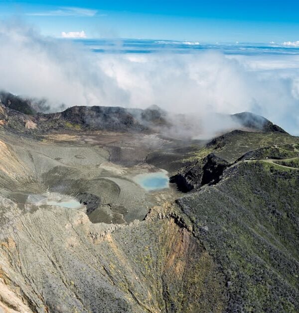 A stunning aerial shot of Turrialba Volcano in Costa Rica with clouds surrounding the crater.