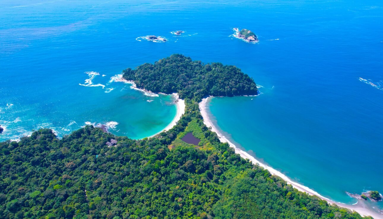 Stunning aerial shot of the lush coastline and turquoise waters of Manuel Antonio National Park, Costa Rica.