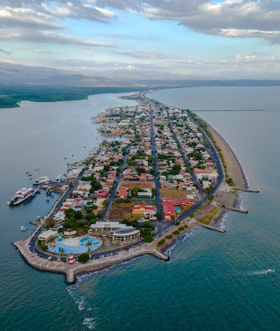 A stunning aerial view capturing the coastal town of Puntarenas, surrounded by shimmering waters and lush landscapes.