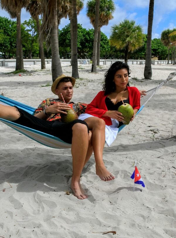Couple enjoying a summer vacation on a tropical Cuban beach, sitting in a hammock.